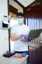 Handsome young man telephone operator worker fixing internet issue connexion at client house with surgical mask and gloves COVID19