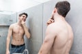 Starting new day with smile. Handsome young man touching his hair with hand and smiling while standing in front of the mirror Royalty Free Stock Photo