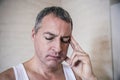 Handsome young man touching his head with one hand feeling strong headache, close up photo