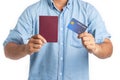 Handsome young man traveler holding passport and credit card isolated on white background. Travel and shopping concept Royalty Free Stock Photo