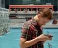 Handsome young man traveling on Hong kong and looking at his mobile phone. Royalty Free Stock Photo