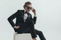 Handsome young man in tuxedo adjusting sunglasses and posing Royalty Free Stock Photo