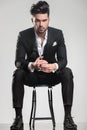 Handsome young man in tuxedo sitting on a stool Royalty Free Stock Photo