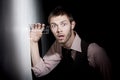 Handsome young man using glass to eavesdrop Royalty Free Stock Photo