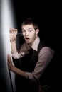 Handsome young man using glass to eavesdrop Royalty Free Stock Photo