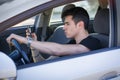 Handsome Young Man Using his Cell Phone Driving a Royalty Free Stock Photo