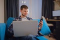 Handsome young man using laptop computer at home. Royalty Free Stock Photo