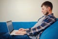 Handsome young man using laptop computer at home. Royalty Free Stock Photo