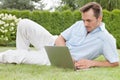 Handsome young man using laptop in park