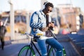 Handsome young man using mobile phone and fixed gear bicycle in the street. Royalty Free Stock Photo