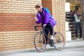 Handsome young man using mobile phone and headphones while riding his bicycle Royalty Free Stock Photo