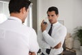 Handsome young man using perfume near mirror Royalty Free Stock Photo