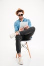 Handsome young man using tablet and sitting on the chair Royalty Free Stock Photo