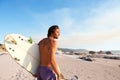 Handsome young man walking on beach with surfboard Royalty Free Stock Photo