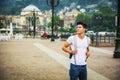 Handsome young man walking in European city square Royalty Free Stock Photo