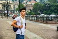 Handsome young man walking in European city square Royalty Free Stock Photo