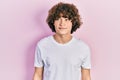 Handsome young man wearing casual white t shirt looking away to side with smile on face, natural expression Royalty Free Stock Photo