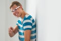 Handsome young man wearing glasses leaning on wall Royalty Free Stock Photo