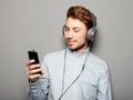 Young man wearing headphones and holding mobile phone Royalty Free Stock Photo