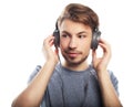 Handsome young man wearing headphones and smiling while standing Royalty Free Stock Photo