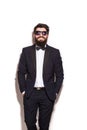 Handsome young man wearing suit and glasses keeping hands in pockets and looking at camera Royalty Free Stock Photo