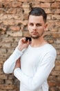 Handsome young man in a white shirt near a brick wall Royalty Free Stock Photo