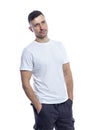 A handsome young man in a white T-shirt stands with his hands in his pockets. Isolated on a white background. Vertical Royalty Free Stock Photo
