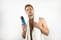 Handsome young man with white towel on his shoulders holding shaving foam in his hand doing his morning routine on