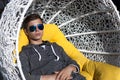 Handsome young man in a wicker chair close-up Royalty Free Stock Photo