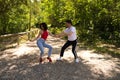 Handsome young man and woman dancing bachata and salsa in the park. The couple dance passionately surrounded by greenery. Dancing Royalty Free Stock Photo