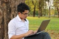 Handsome young man working with a laptop computer in blurred nature background Royalty Free Stock Photo