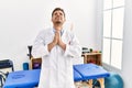 Handsome young man working at pain recovery clinic begging and praying with hands together with hope expression on face very Royalty Free Stock Photo