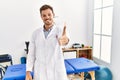 Handsome young man working at pain recovery clinic smiling friendly offering handshake as greeting and welcoming Royalty Free Stock Photo