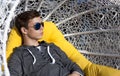 Handsome young man in a wicker chair close-up Royalty Free Stock Photo
