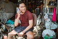 Handsome young mechanic making a cell phone call in an old garage