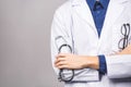 Handsome young medic doctor holding a stethoscope, isolated over grey background