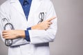 Handsome young medic doctor holding a stethoscope, isolated over grey background