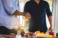 Handsome young man in casual wear handshake at home preparing cooking in kitchen