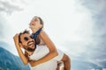 Young man giving piggyback ride to girlfriend on beach. Romantic young couple enjoying summer holidays Royalty Free Stock Photo