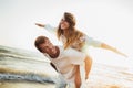 Young man giving piggyback ride to girlfriend on beach. Young couple enjoying summer holidays Royalty Free Stock Photo