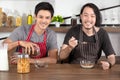 Handsome young men having breakfast, one man pouring cereal into glass bowl and the other holding spoon in modern dining room Royalty Free Stock Photo