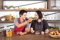 Handsome young men having breakfast together, one man feeding cereal to the other in modern dining room apartment on weekend. Royalty Free Stock Photo