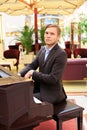 Handsome young men playing piano at the restaurante Royalty Free Stock Photo