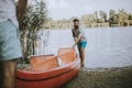 Young man pulling canoe into calm lake Royalty Free Stock Photo
