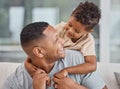 Handsome young mixed race man and his adorable son hugging on a sofa in the living room at home. Father and his boy Royalty Free Stock Photo