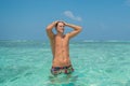 Handsome young model man in the ocean at tropical beach in island luxury resort Royalty Free Stock Photo
