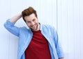 Handsome young modern man smiling with hand in hair