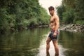 Handsome young muscle man standing in water pond, naked