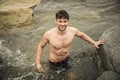 Handsome young muscle man standing in water pond, shirtless