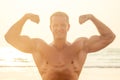 Handsome young muscular male model doing the workout stretching warm up on the beach summer.sexy athlete abs and perfect Royalty Free Stock Photo